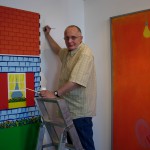 Ken Elias retouching his painting 'Days are where we live' hung alongside an Ernest Zobole painting, Zobole Gallery 2006